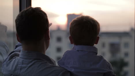 Padre-Feliz-Con-Su-Pequeño-Hijo-Cerca-De-La-Ventana