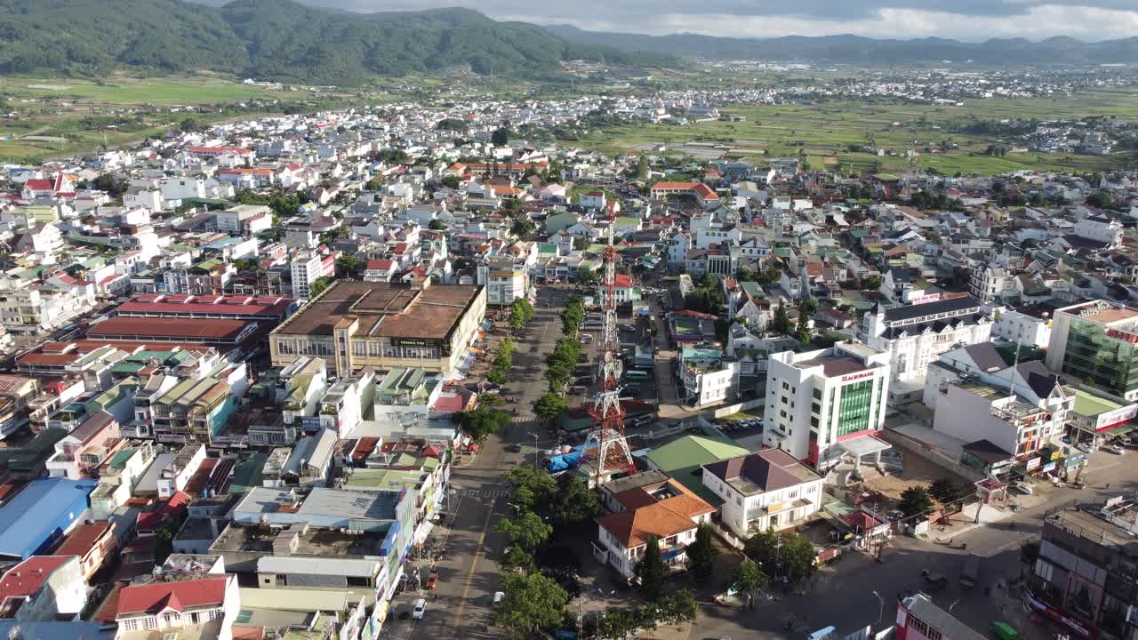 Góc nhìn từ trên cao bằng flycam trên Thành phố Hà Giang cho thấy các tòa nhà dân cư dày đặc, những con phố trung tâm và tháp viễn thông, cùng với núi xanh và cảnh quan thung lũng rộng lớn ở miền Bắc Việt Nam.