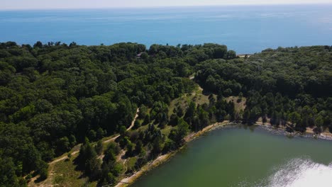 Forward-motion-over-lush-trees-to-show-lake-Michigan