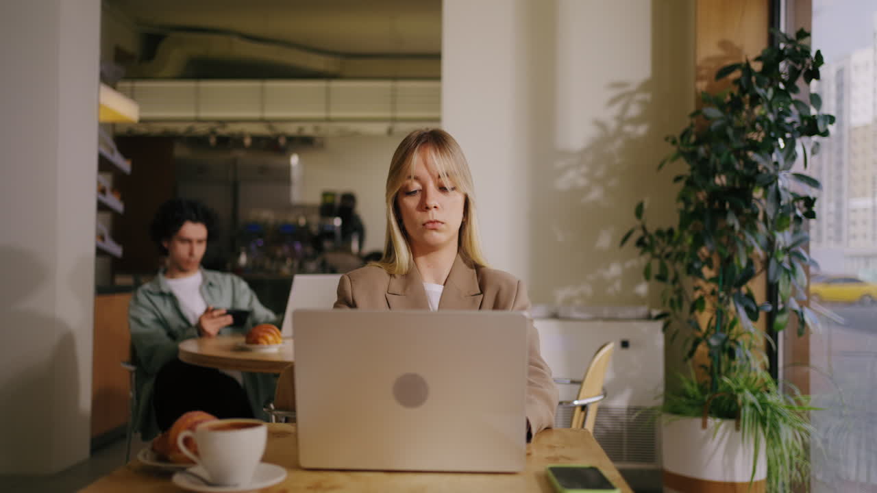 Una donna lavora al suo laptop in un bar