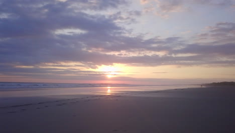 Tracking-shot-of-footsteps-in-sand-on-Costa-Rican-beach-during-beautiful-sunset