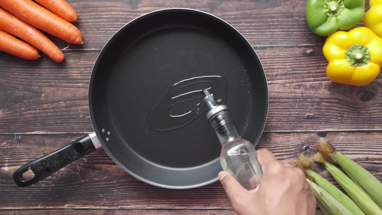 preparar comida vertiendo aceite en una sartén