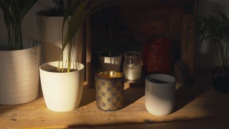 beautiful home decor with plants and candles on cupboard in dim light