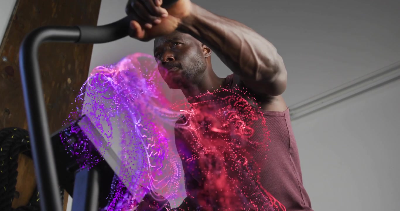 Hombre adulto presionando un botón de consola y pedaleando mientras partículas digitales visualizan métricas de fitness