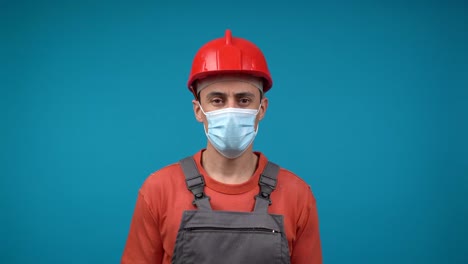construction worker wearing a red hard hat and medical mask