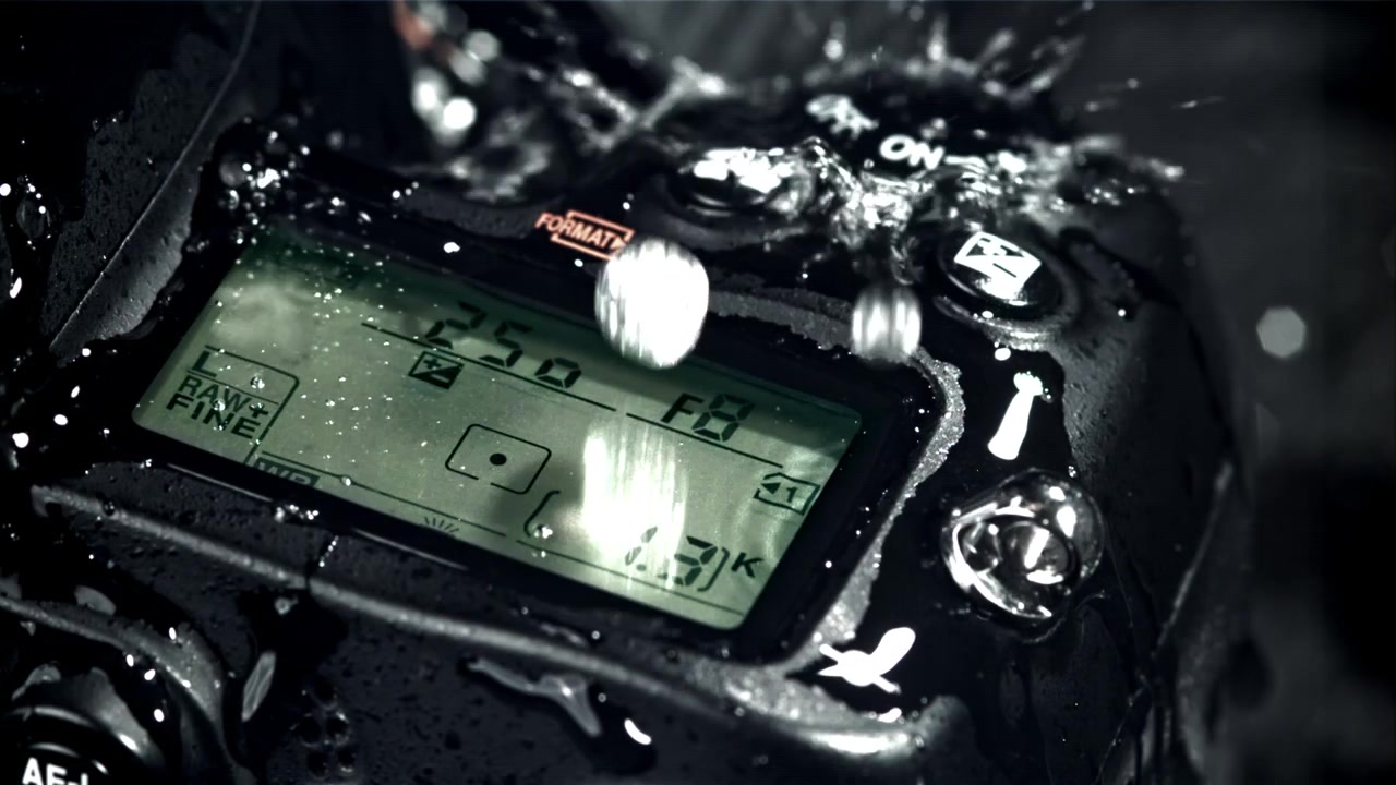 Gocce d'acqua che schizzano sul display superiore di una fotocamera DSLR