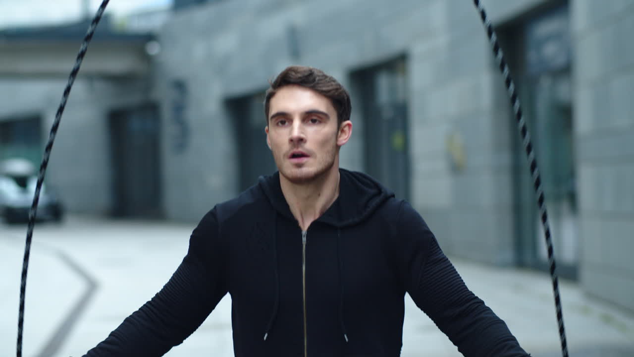 스포티한 남자가 점프 로프에 뛰어다니고 있다. 클로즈업에 집중한 남자가 점프 운동을 훈련하고 있다.