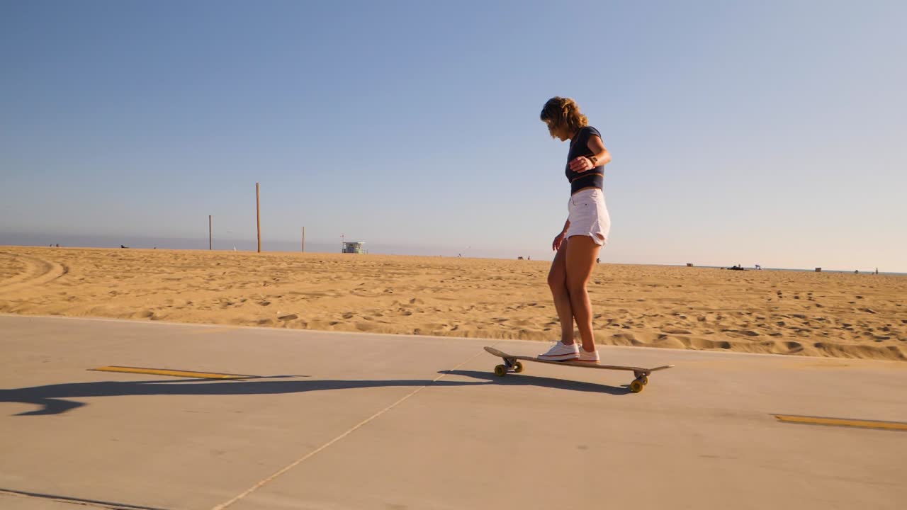 mujer joven deportiva con ropa informal patinando en un soleado parque del desierto
