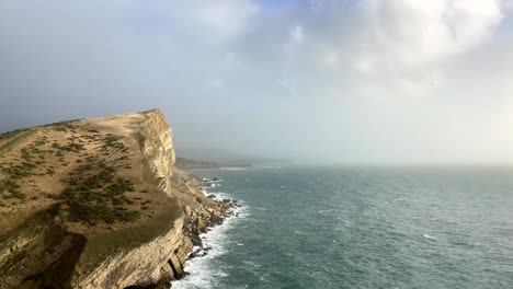 Bella-Toma-Del-Borde-De-Un-Acantilado-Y-El-Océano-En-La-Costa-Jurásica,-Inglaterra