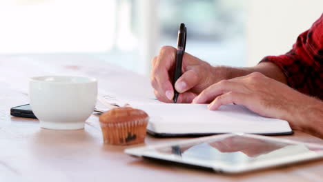manos de un hombre de negocios casual escribiendo en papel