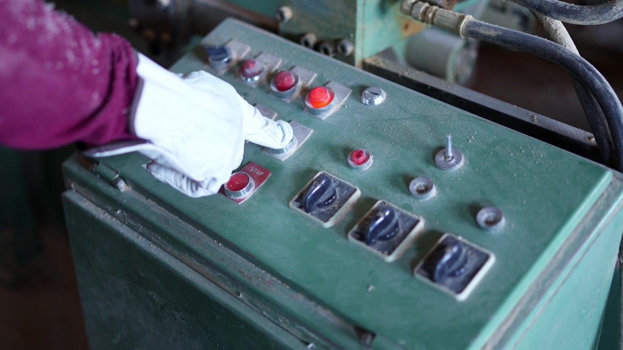 Person in glove pushing button on dusty control panel
