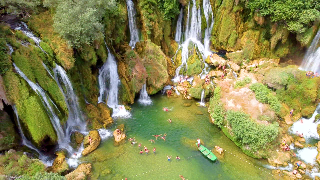 Cascata di Kravica - Cascata di tufo sul fiume Trebizat con turisti in una giornata di sole in estate in Bosnia ed Erzegovina. - Ascesa aerea, allontanamento.