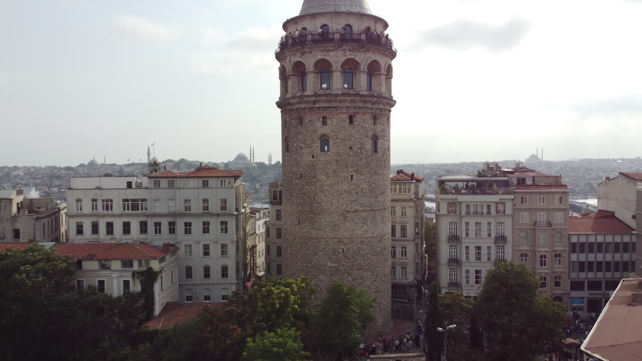 el avión no tripulado sube para revelar la vista de la torre galata en beyoglu istanbul con el mar del bósforo, las mezquitas, el puente galata en el fondo detrás