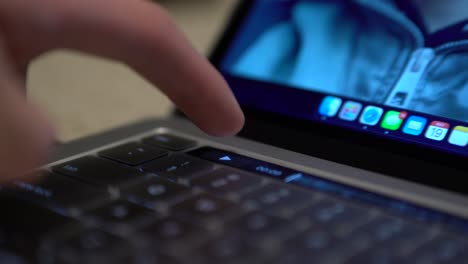 close up of pro laptop touch bar strip with finger pressing video pause button