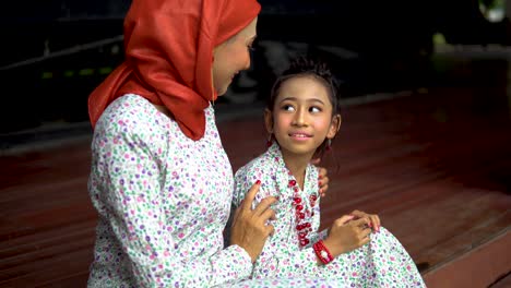 mother and daughter moment, outdoor wearing traditional dresses for raya celebration