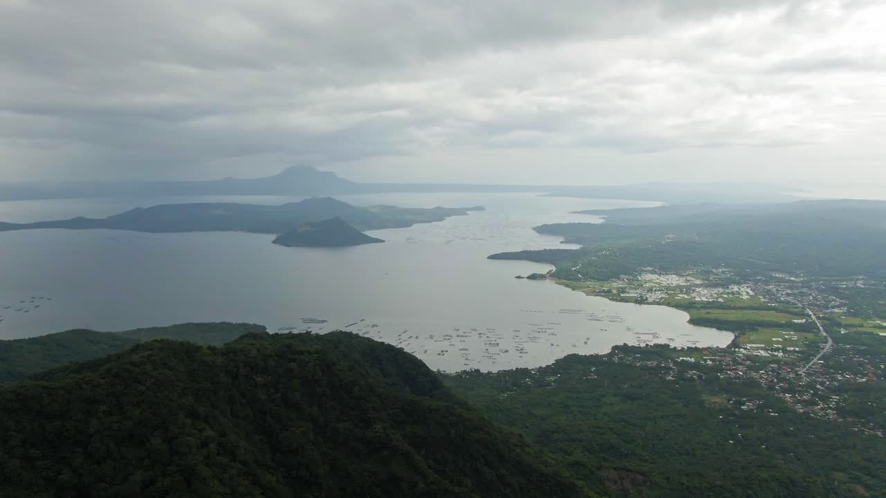 흐린 하늘 아래 고요한 안개 낀 타알 호수로 둘러싸인 타알 화산의 경치 좋은 눈 캡처