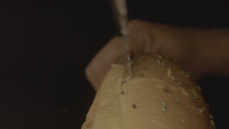 macro tiro de pan de hamburguesa que se abre con un cuchillo de pan