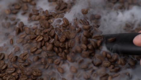 cuchara de café recogiendo granos de café con humo por todas partes en súper cámara lenta