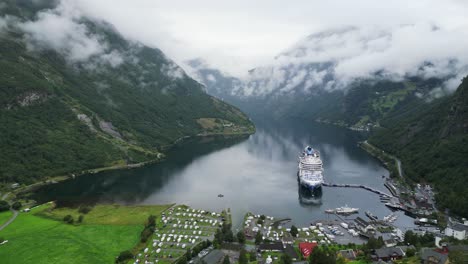 Cruise-Ship-in-Geiranger,-Norway---Scenic-Geirangerfjord-and-Small-Village-in-Stranda,-More-og-Romsdal---Aerial