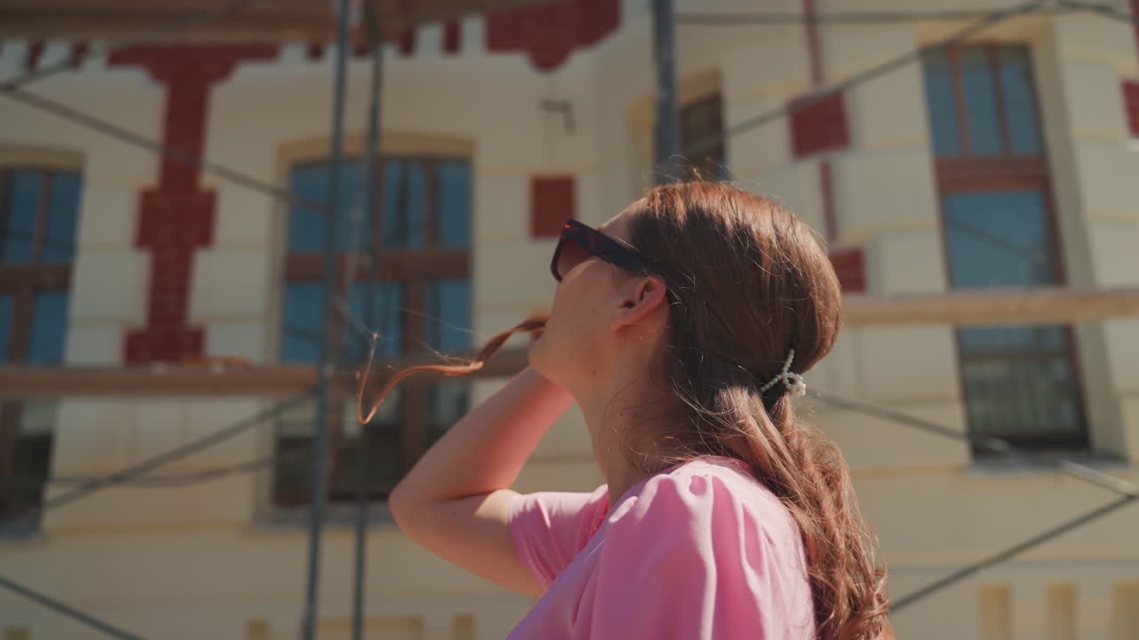 Donna che ammira un'impalcatura, studio di una facciata illuminata dal sole con atmosfera da sito di restauro di un edificio storico, mattoni decorati, impalcature, architetto che ispeziona, turista che ammira, restauratore