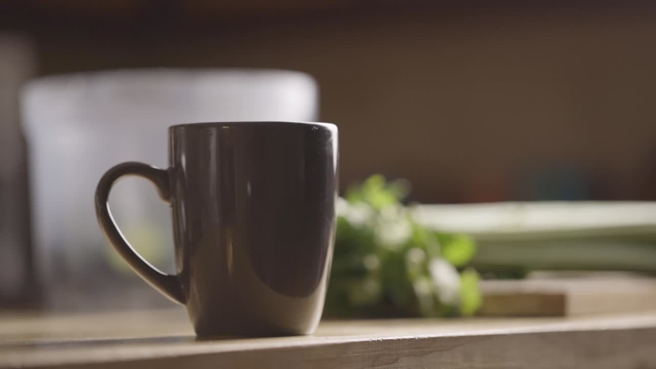 한 남자가 테이블 위에 음료수 컵을 놓는다