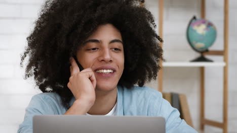 un joven hablando por teléfono en la oficina.