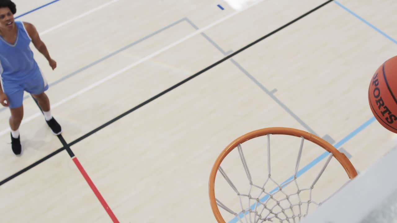 alto ángulo de entrenamiento diverso del equipo de baloncesto masculino en la cancha cubierta y canasta de puntuación, cámara lenta
