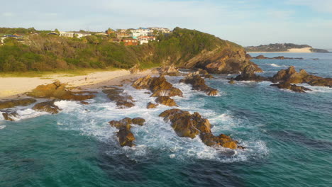 olas rompiendo contra la rocosa costa australiana, vista aérea de la puesta de sol