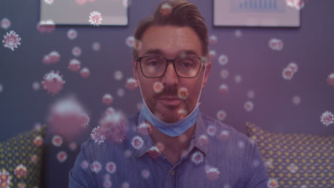 animación de células de virus flotando sobre hombre de negocios caucásico con máscara facial hablando en la oficina
