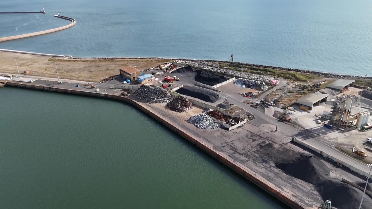 Vista aérea de un vertedero industrial junto a las aguas portuarias en un puerto del Reino Unido.