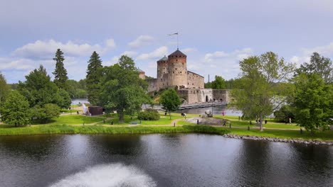 Flying-Drone-Dolly-Shot-Approaching-Medieval-Castle-Olavinlinna-on-a-Summer-Day-in-Savonlinna