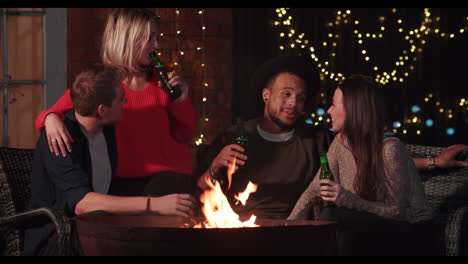 grupo de amigos disfrutando de bebidas nocturnas junto a la chimenea