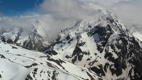 vuelo aéreo a través de nubes montañosas sobre hermosos picos nevados de montañas y glaciares.