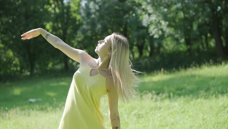 happy beautiful young girl dancing of freedom in summer park with trees in the background.