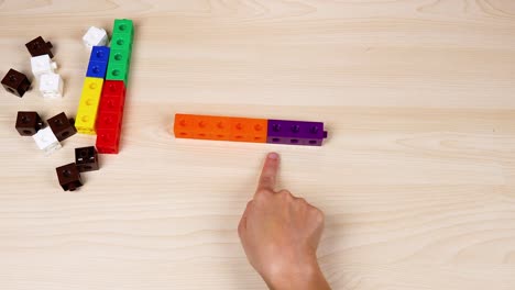 las manos manipulan cubos en una superficie de madera