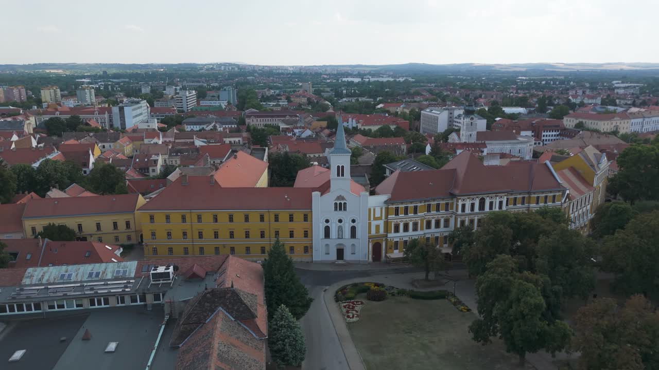 Drone view of Our Lady Church of the Female Order of Notre Dame in Pécs, surrounded by rooftops and the historic cityscape