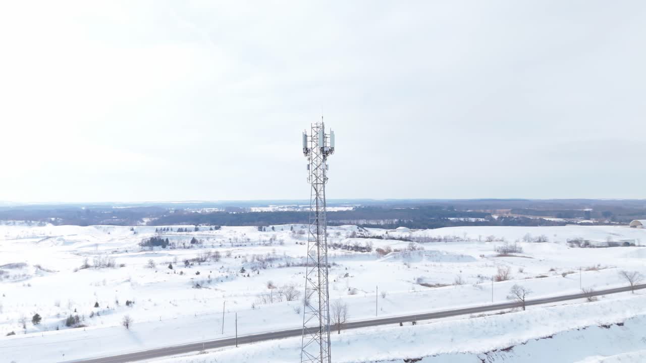 Telecommunication Tower During Winter In A Snow Covered Landscape, Orbiting Aerial Shot