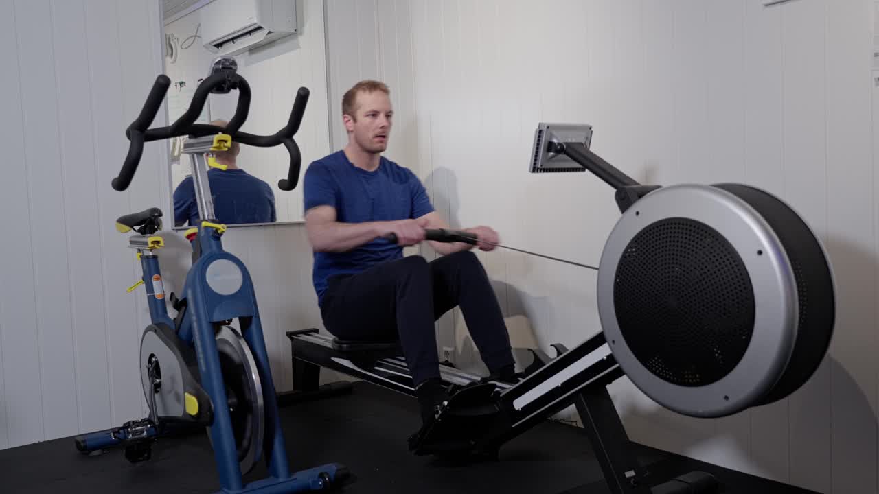 Middle-aged Caucasian Man Engaged in Home Gym Rowing Workout