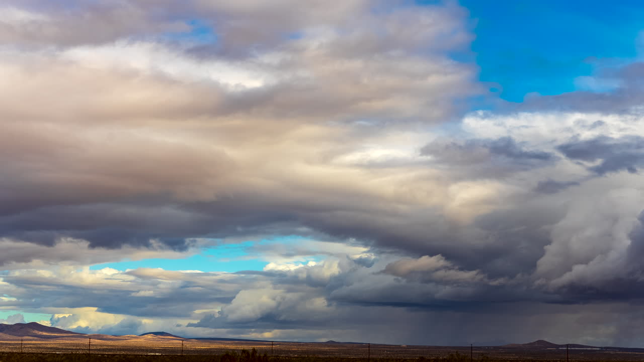 cloudscape dinámico con cizallas de viento empujando capas de nubes en diferentes direcciones sobre la cuenca del desierto de mojave - lapso de tiempo