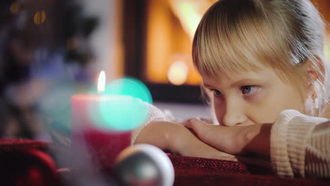 Retrato-De-Un-Niño-Mira-Una-Vela-Pide-Un-Deseo-En-Nochebuena