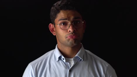 sad and confused man pouting its lips in black background