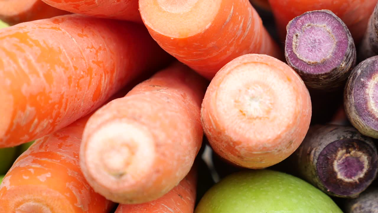 Närbild på orangea och lila morötter