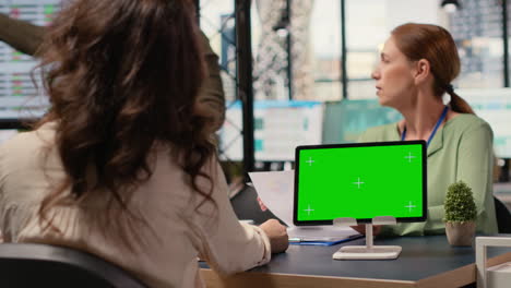 vertical video group of businesswomen reviews project analytics with green screen