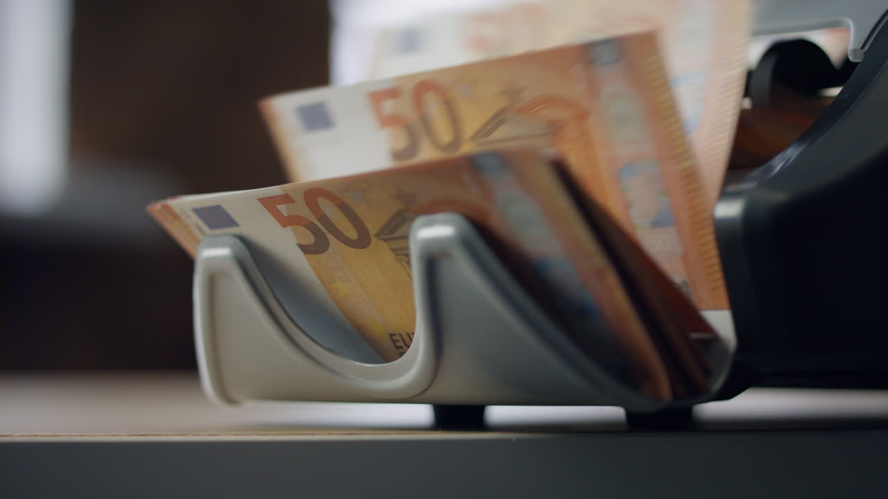 Nahaufnahme einer Maschine, die Euroscheine zählt. Maschine zählt europäische Währung.