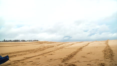 a blue chair flies through the air at the beach in slow motion as if blown by the wind