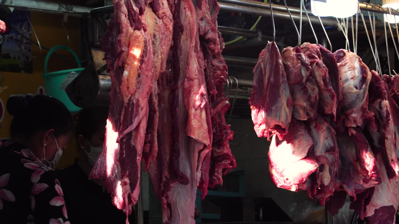 carne cruda appesa in una macelleria asiatica nel mercato umido