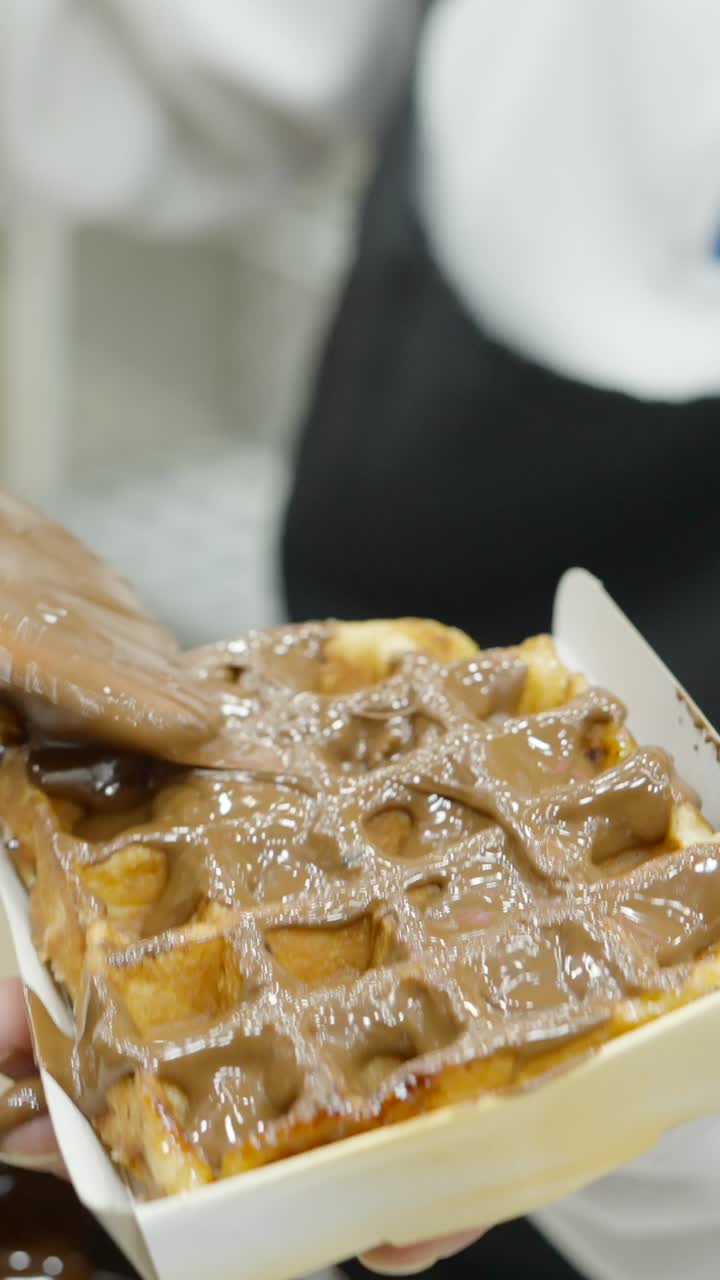 Pouring chocolate on a waffle