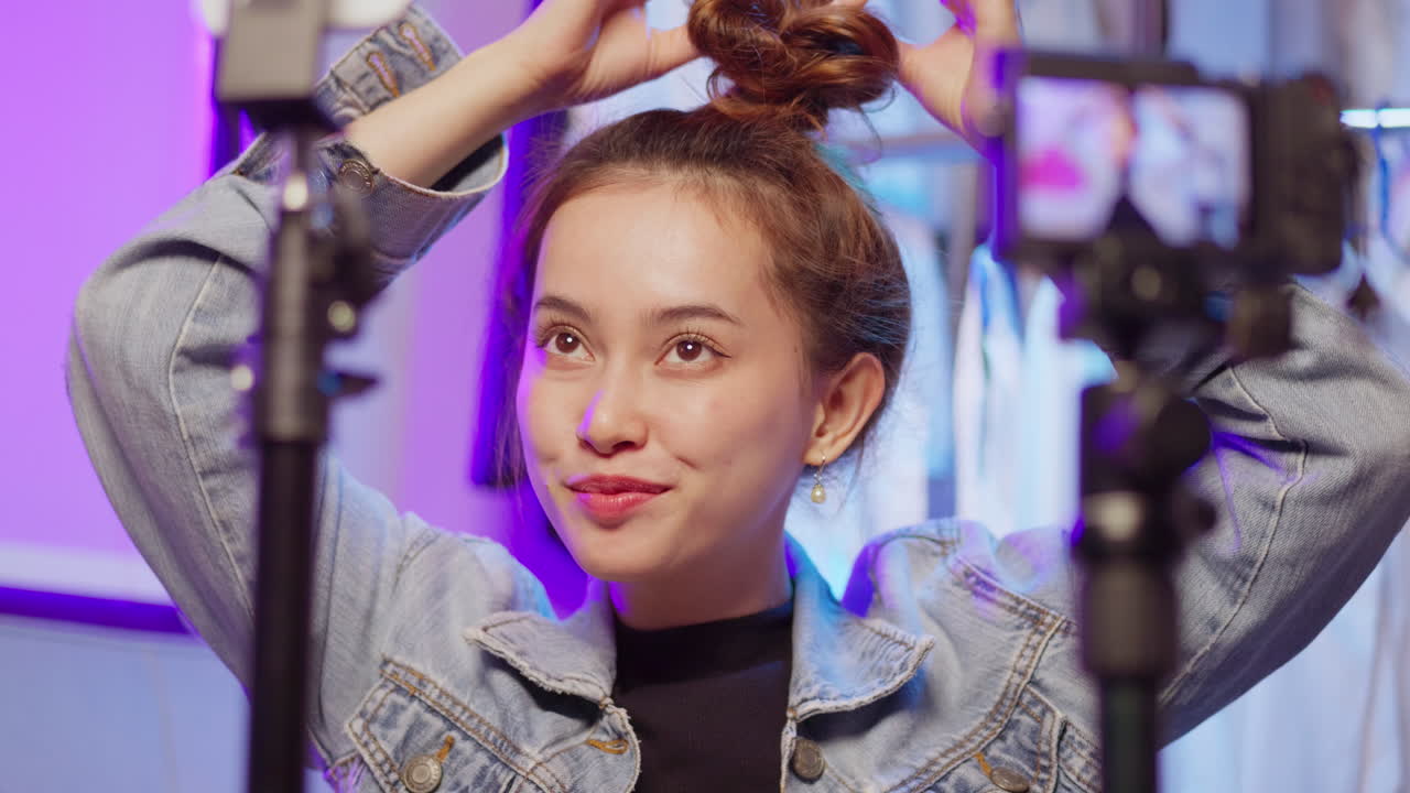 A lively beauty tutorial showcasing an influencer styling her hair against a colorful urban backdrop.