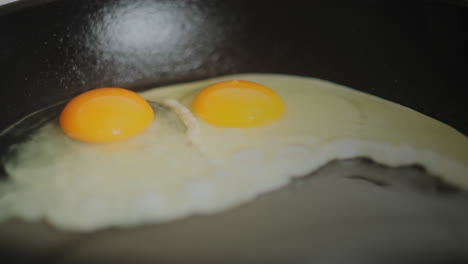 un huevo que se rompe en una sartén con aceite