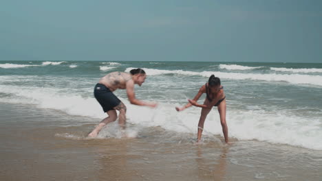 pareja jugando en la orilla